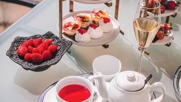 A three-tiered dessert stand with various pastries and a glass of champagne.