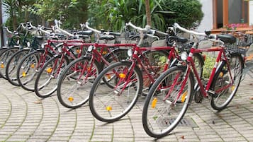 A row of bicycles parked in a designated area with a paved ground.