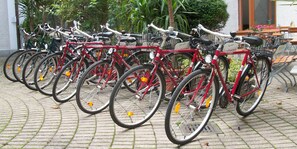 Varias bicicletas aparcadas en un área designada con suelo pavimentado.