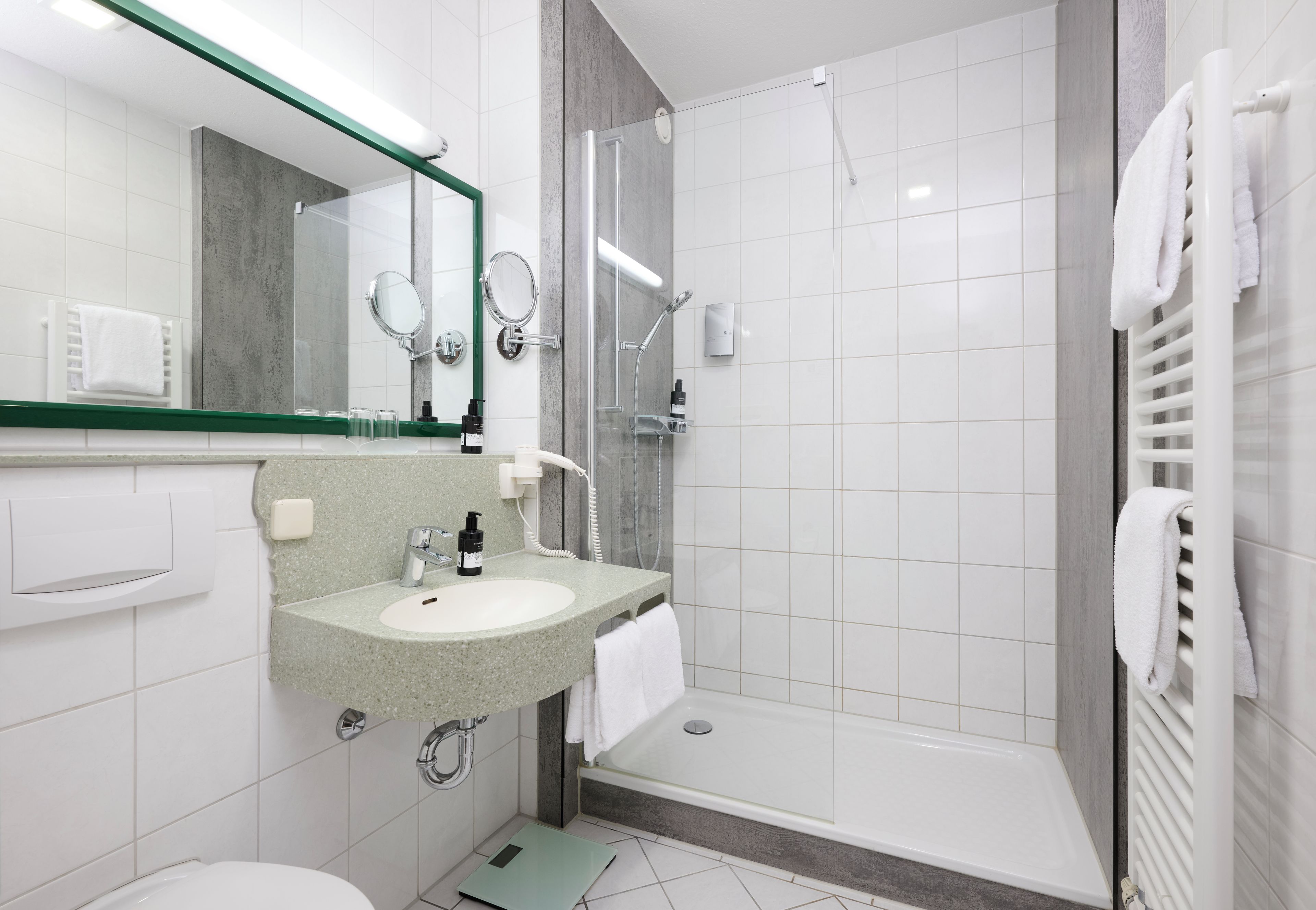 A modern bathroom with a sink, mirror, and shower.
