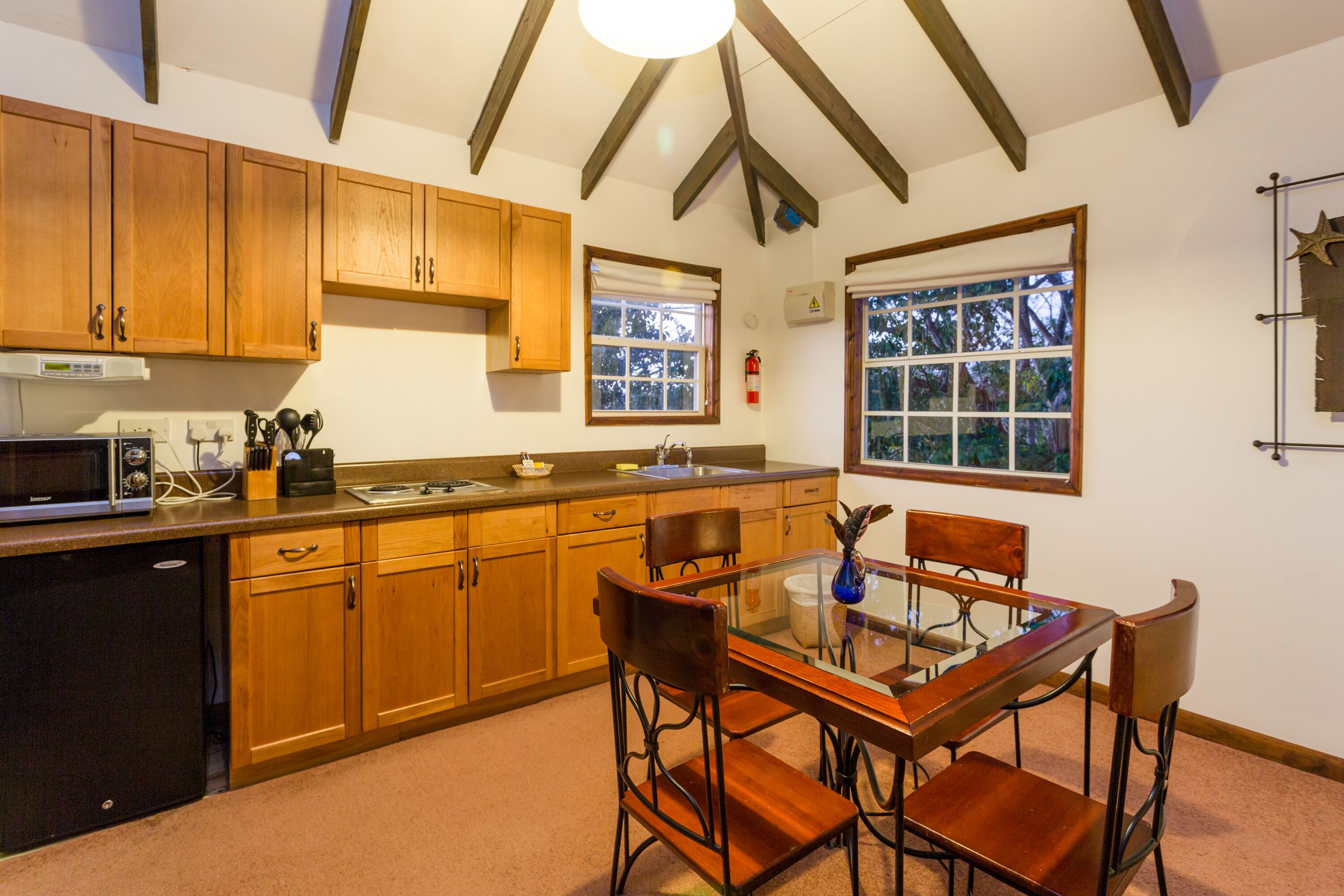 A kitchen with wooden cabinets, a microwave, and a dining table with chairs.