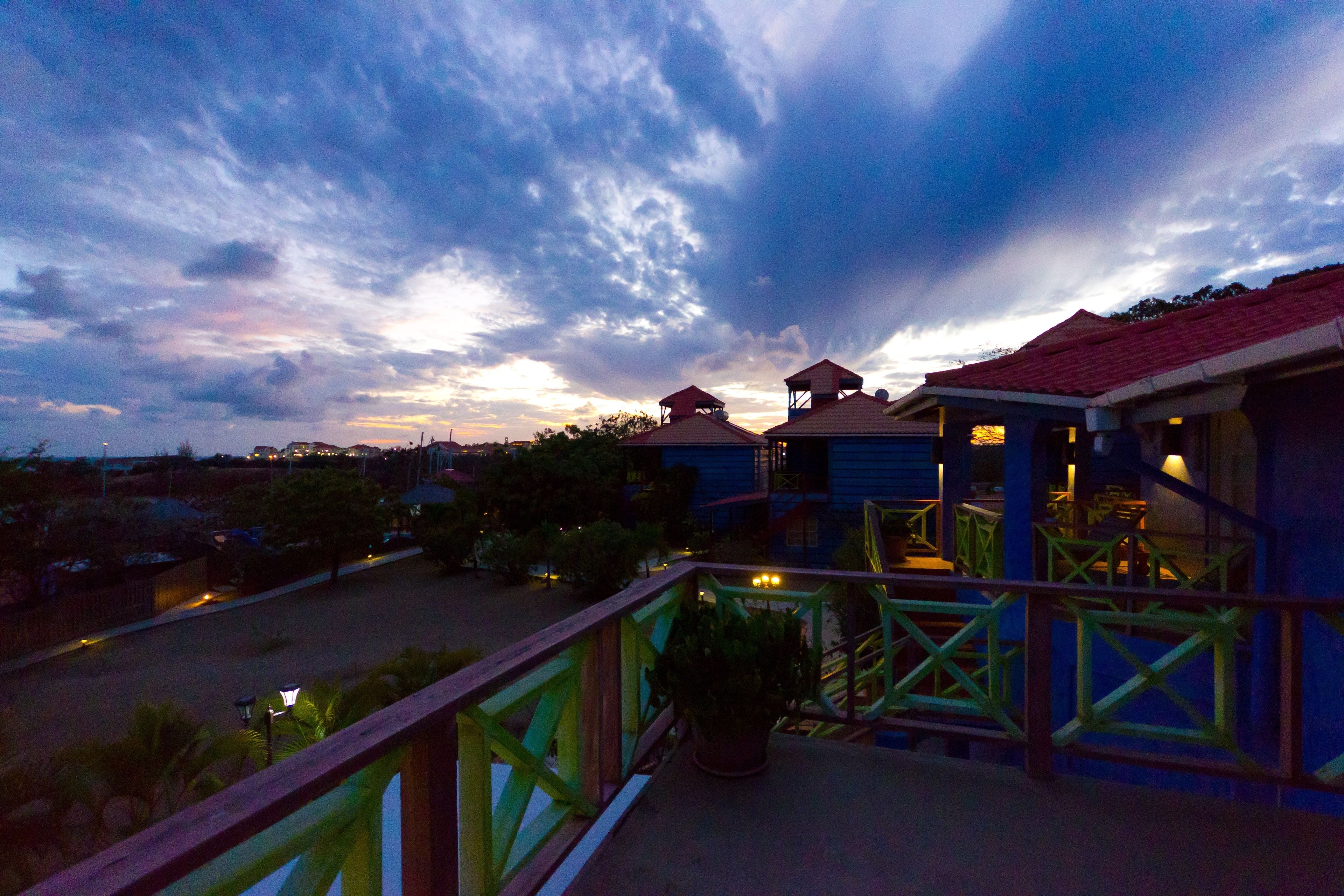 A balcony with a view of a residential area during twilight.