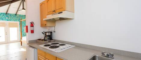 A kitchen with wooden cabinets, a stainless steel sink, and a white stove.