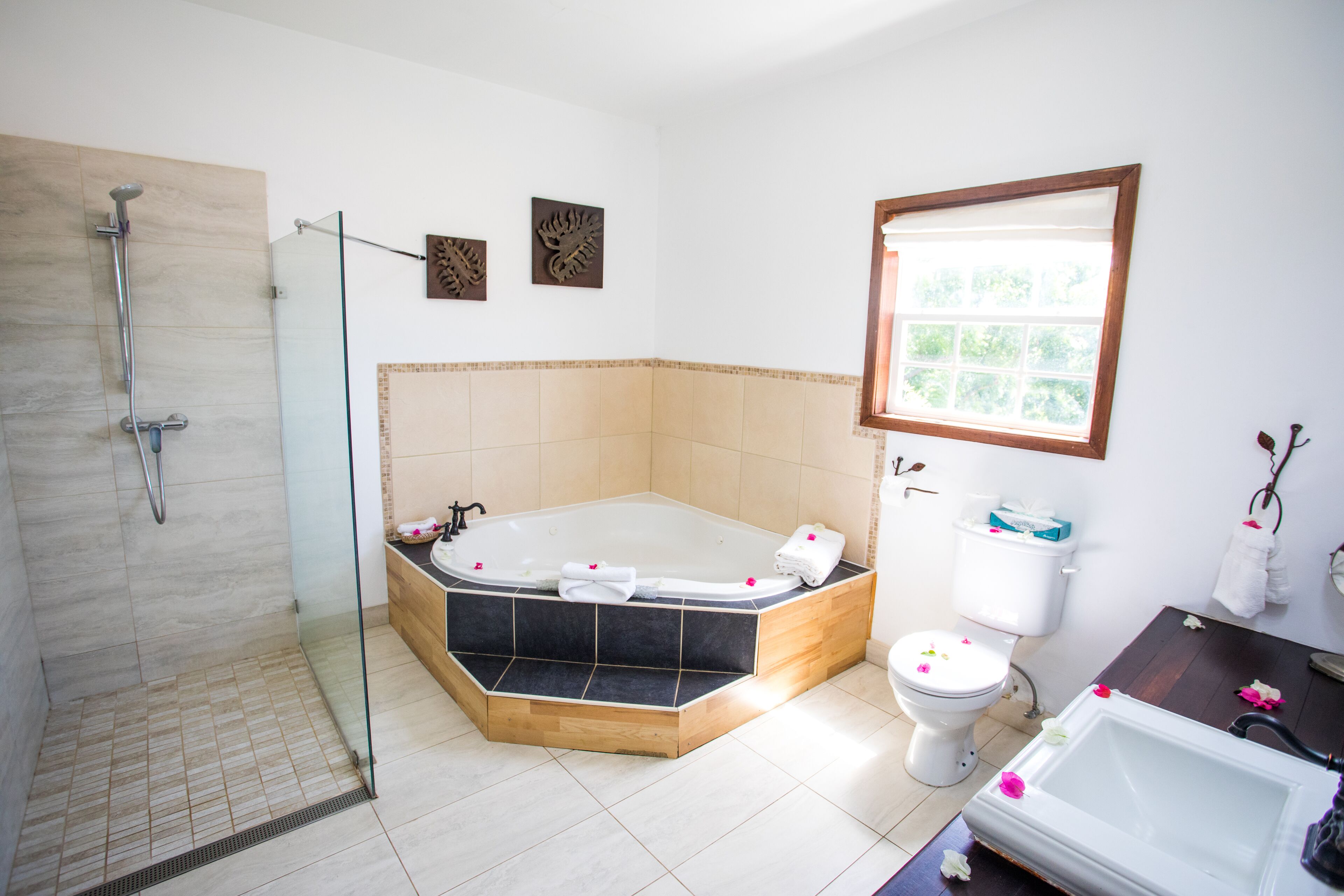 Un baño moderno con ducha de vidrio, bañera independiente, inodoro y lavamanos.