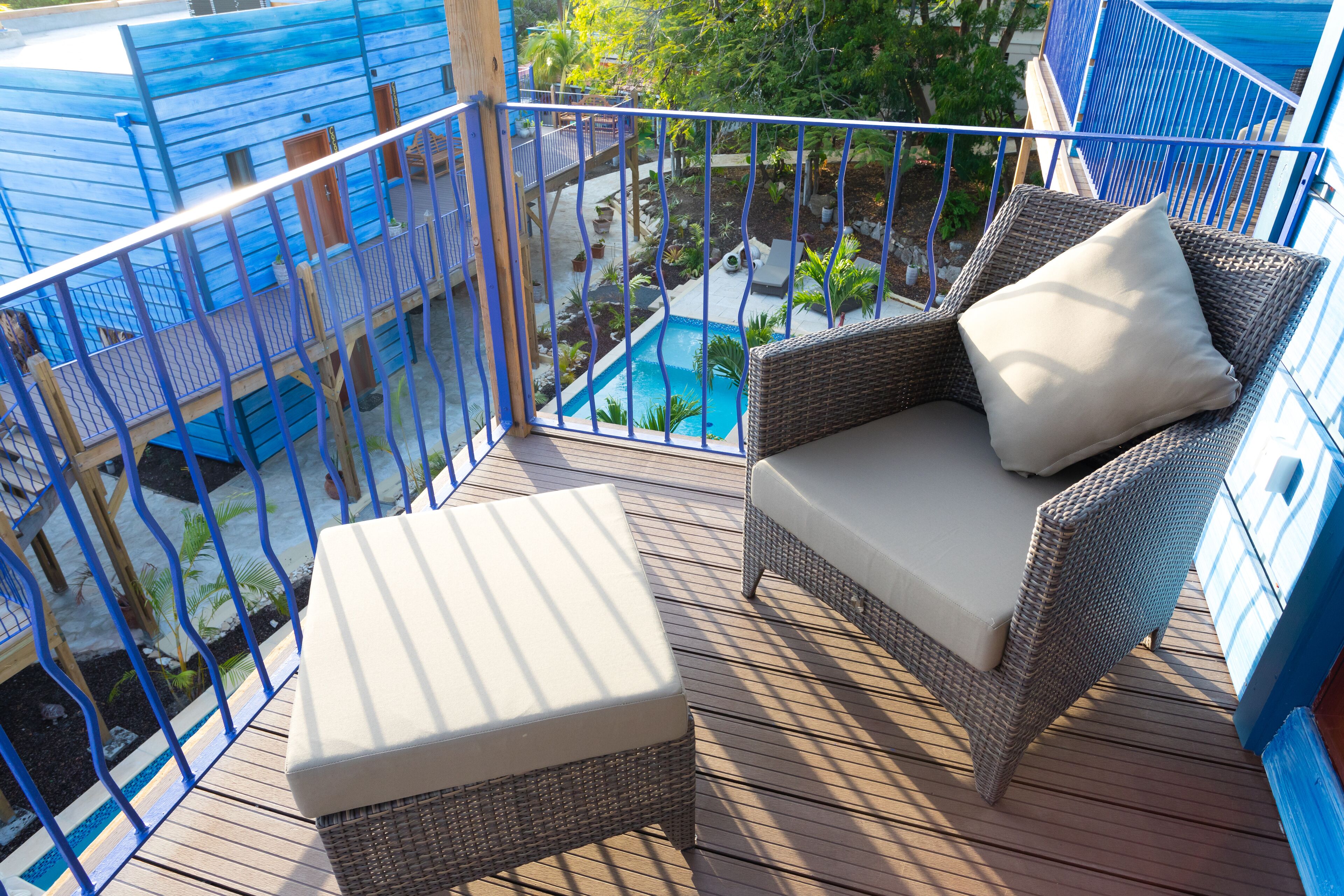 A balcony with wicker furniture, a small pool, and a view of the surrounding area.