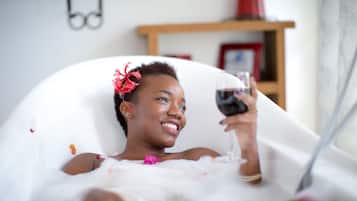 Relax in a serene space with a bathtub, wine, and a peaceful ambiance.