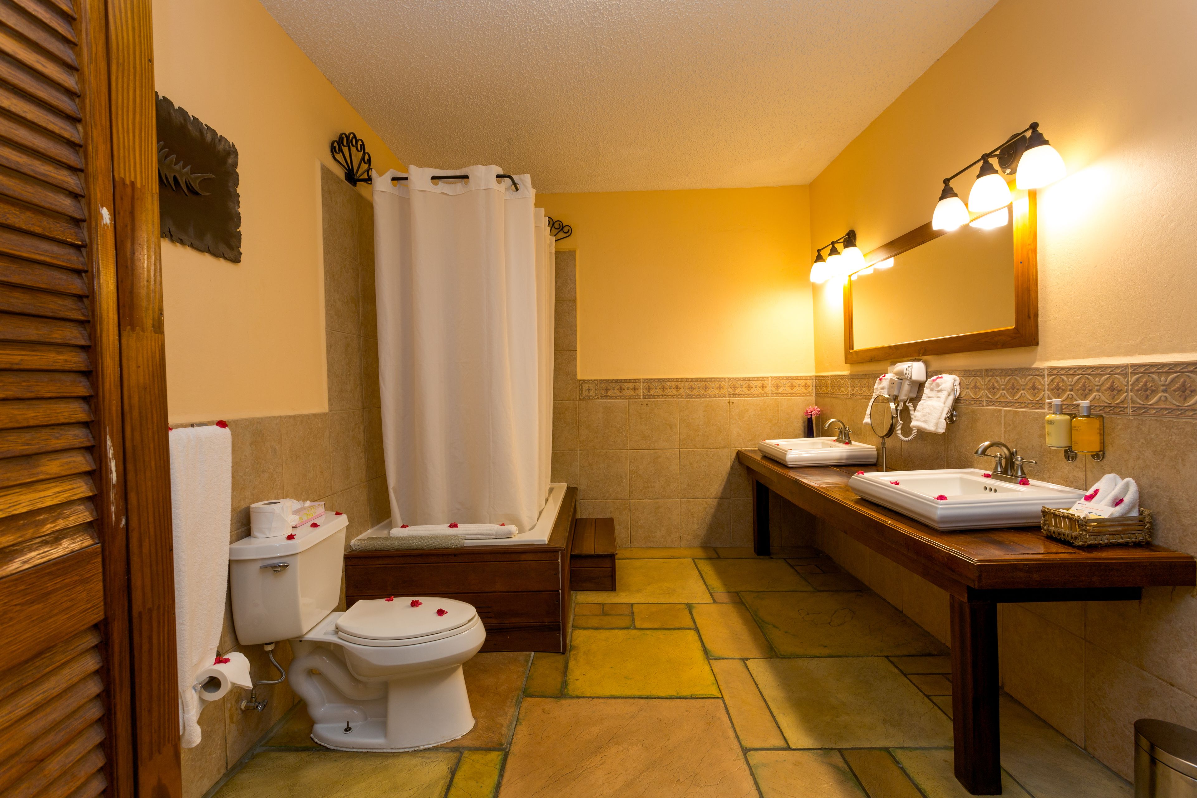 Un baño con inodoro, bidé, lavamanos y ducha.