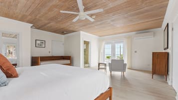 A bedroom with a wooden ceiling, a bed, a chair, and a wardrobe.