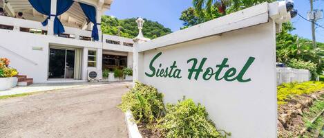 A hotel entrance with a sign reading "Siesta Hotel."
