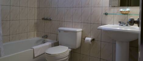 Un baño con bañera, inodoro y lavamanos.
