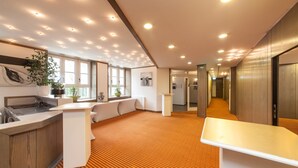 Eine moderne Hotelhalle mit Küchenbereich, einer Rezeption und einer langen Diele.