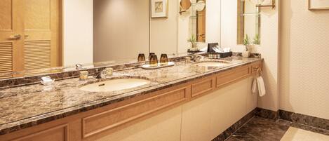 A modern bathroom with a large vanity, two sinks, a mirror, and a towel rack.