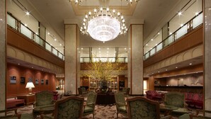A spacious lobby with a grand chandelier, multiple seating areas, and a central floral arrangement. - Hotel Agora Regency Osaka Sakai (Sakai)