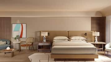 Quarto de hotel com uma cama grande, duas mesas de cabeceira, um sofá, uma poltrona e uma pequena mesa com abajur.