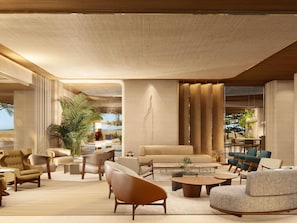 Un vaste espace salon offrant différents types de sièges, notamment des canapés et des fauteuils, disposés autour d’une table basse centrale.