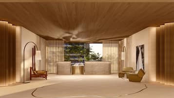 Une pièce spacieuse avec un plafond haut, une grande fenêtre donnant sur les arbres, un canapé, un fauteuil et une table.
