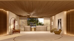 A spacious room with a high ceiling, a large window with a view of trees, a sofa, a chair, and a table.