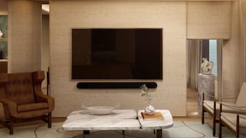 Uma sala de estar moderna com uma televisão de tela plana na parede, uma mesa de centro de mármore com objetos decorativos e uma poltrona marrom.