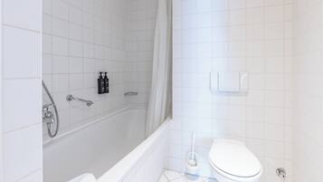 Une salle de bain avec une baignoire, des toilettes et une douche.