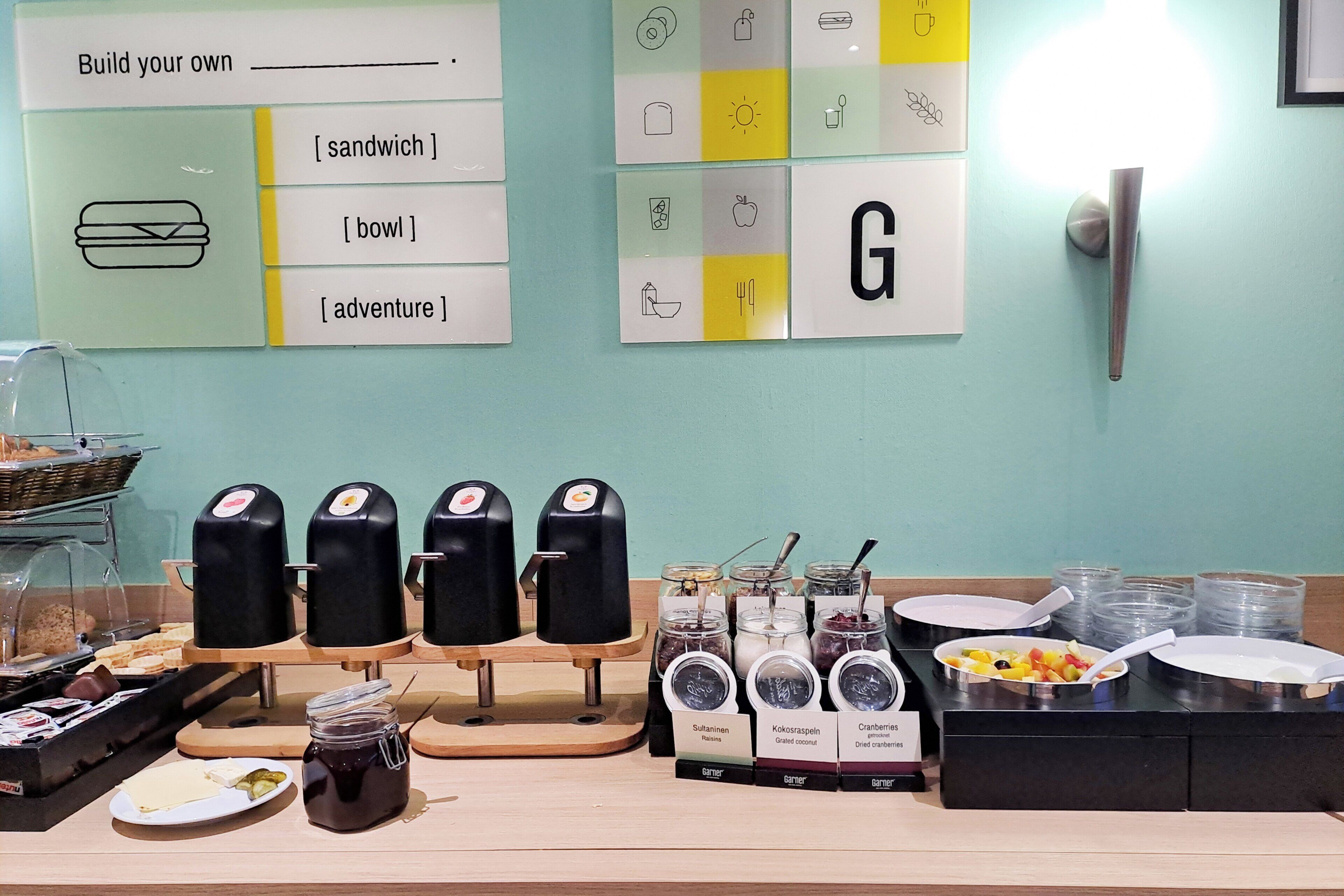 Un bufé de desayuno con diversas opciones de comida y un letrero con espacio para personalización.