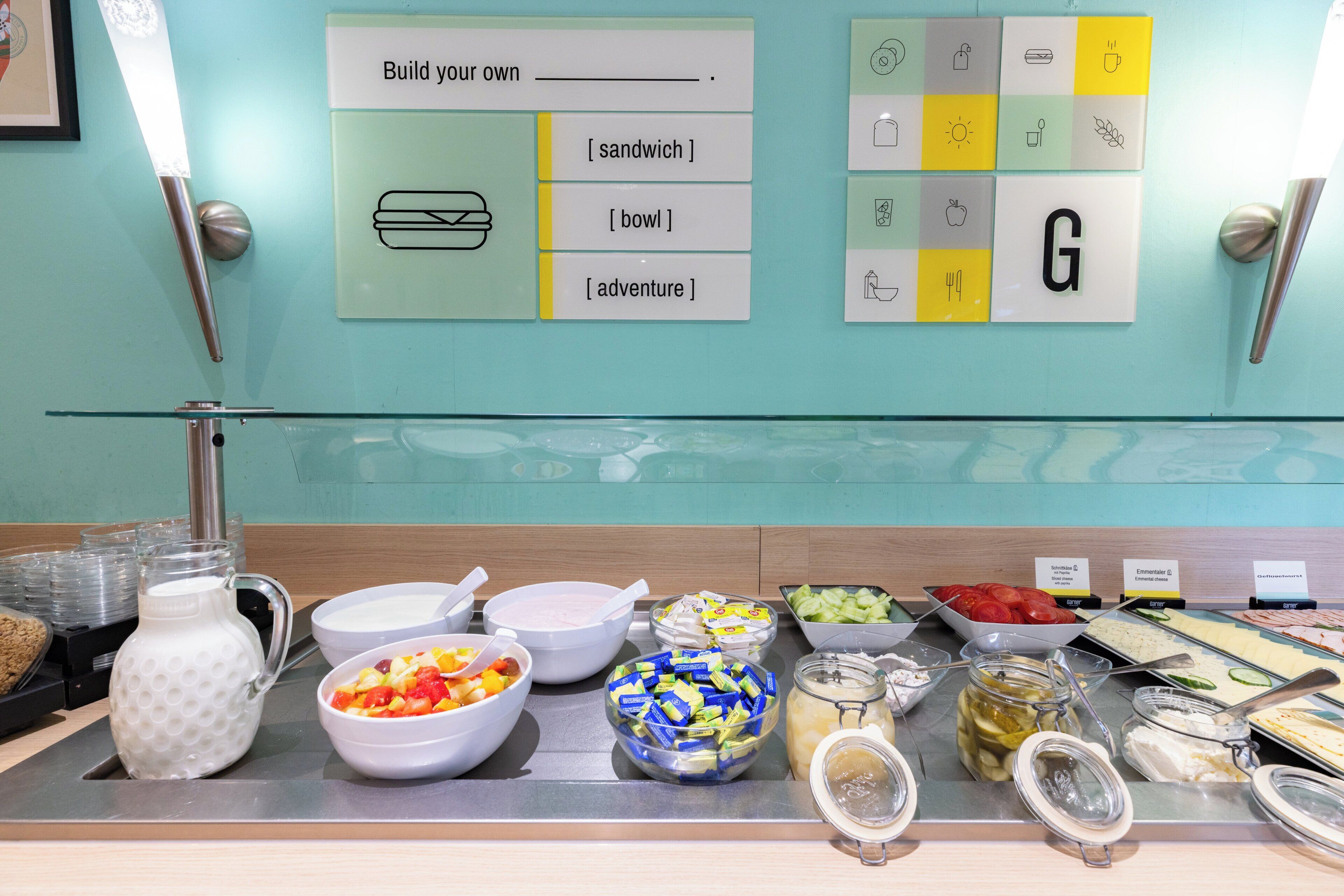 A buffet with various food options and a sign indicating a customizable sandwich.