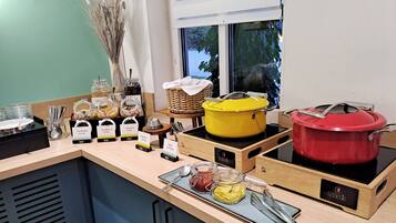 A buffet setup with various food items and cooking equipment.