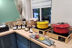 A buffet setup with various food items and cooking equipment.