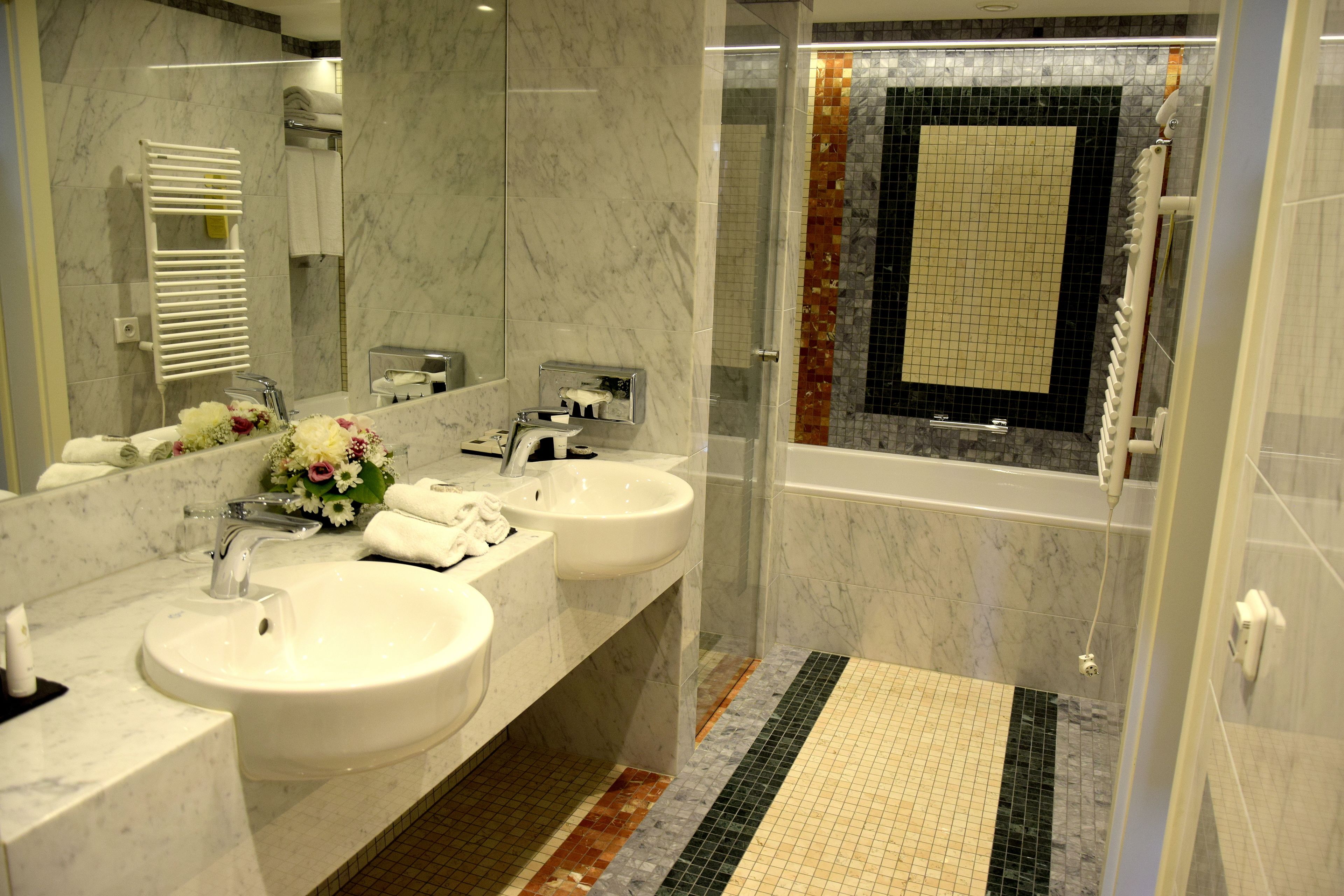 Ein modernes Badezimmer mit zwei Waschbecken, einem großen Spiegel und einer Duschkabine.
