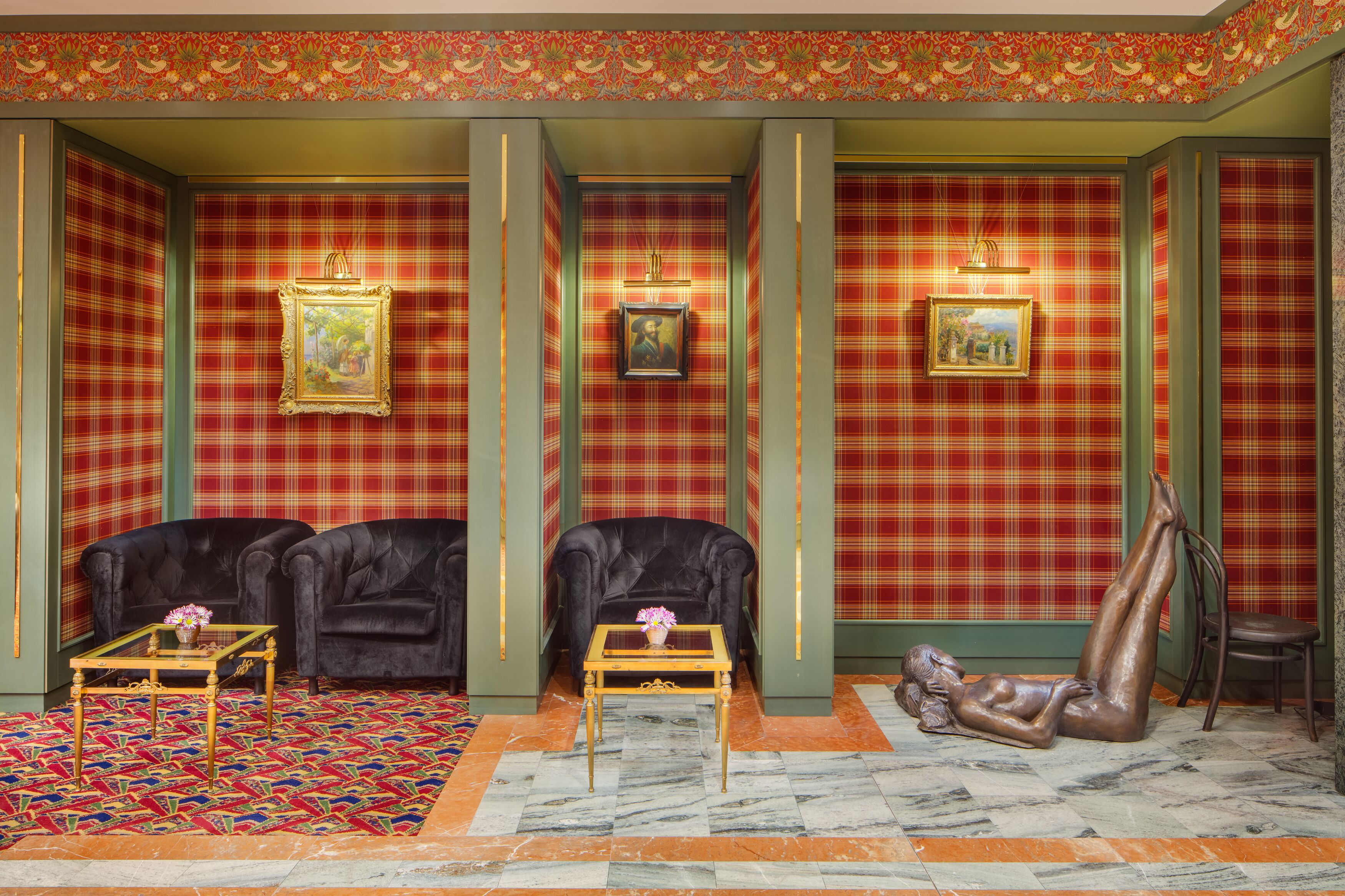 A room with a checkered floor, two black leather sofas, a marble floor, and a statue of a reclining figure.