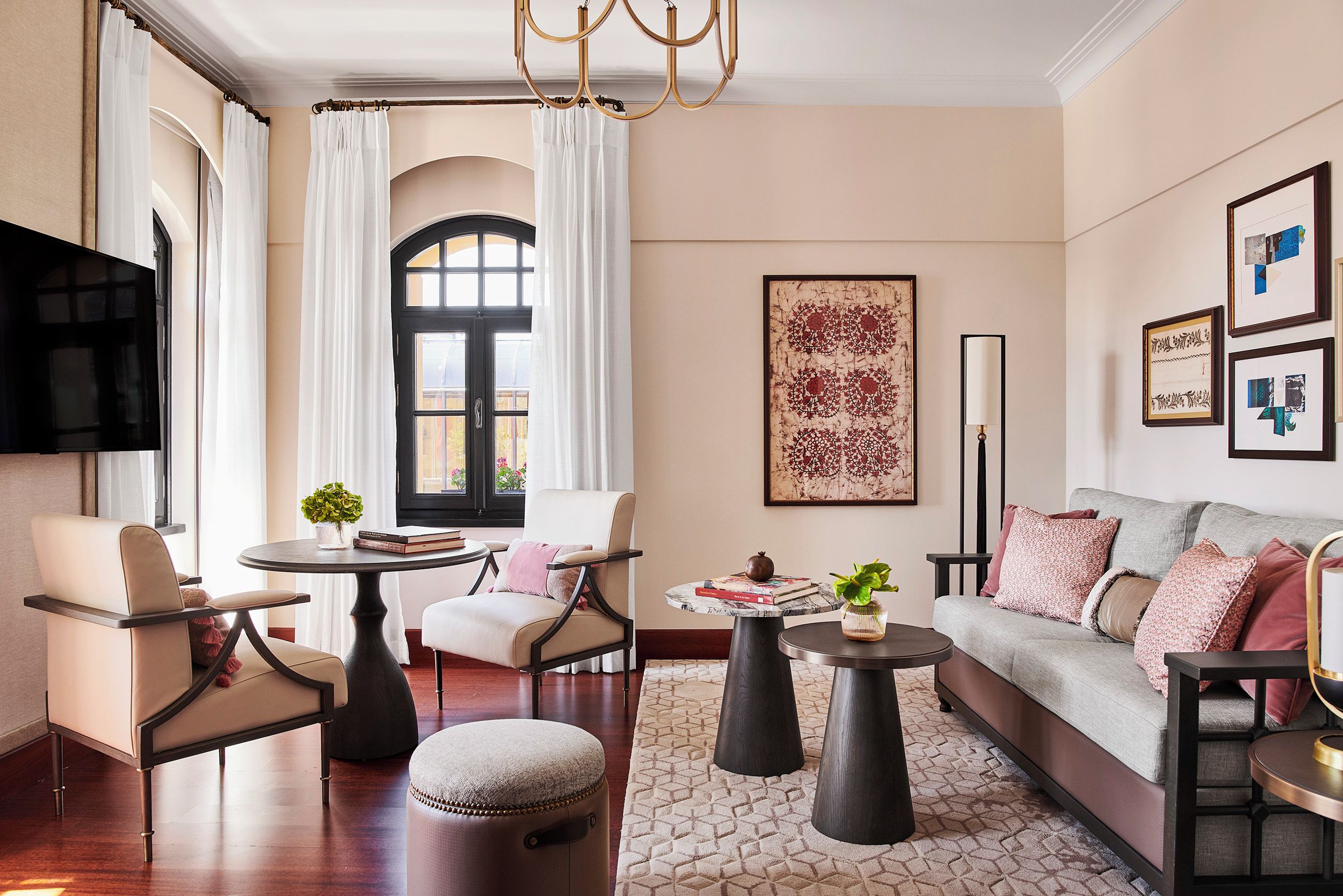 A modern living room with a sofa, armchairs, a coffee table, and a television.