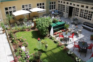 Un cortile con posti a sedere all'aperto, una bicicletta e piante in vaso.