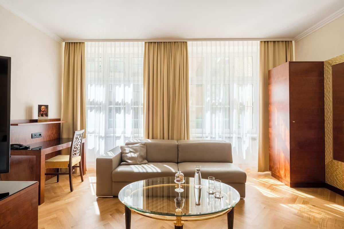 Uma sala de estar moderna com sofá, mesa de centro de vidro e televisão.