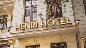 A hotel sign with illuminated letters spelling "HENRI HOTEL" on a building facade. - Henri Hotel Berlin (Berlin)