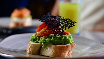 A sandwich with avocado and tomato on a plate.