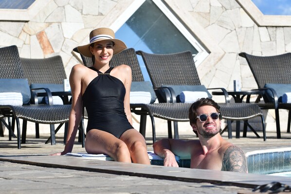 A pool area with lounge chairs and a stone wall in the background. - Hotel Atlante Plaza (Recife)