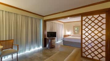 A hotel room with a bed, a TV, a sofa, and a chair.