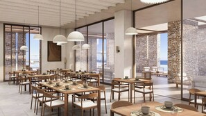 A spacious dining area with multiple tables and chairs, large windows offering a view of the sea, and modern pendant lighting. - Golden Beach Tinos (Tinos)