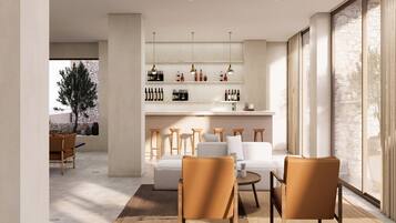 Una sala de estar moderna con un sofá, sillones y una vinoteca.