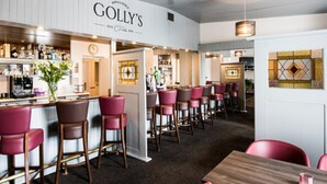 A bar area with a sign reading "GOLLY'S" and multiple bar stools. - Carna Bay Hotel (Carna)