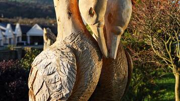Una escultura de dos cisnes en un jardín.