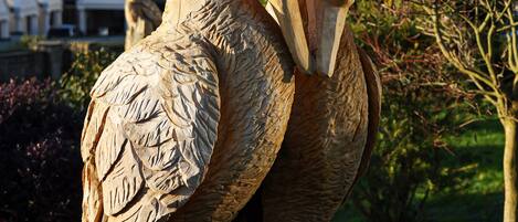 A sculpture of two swans in a garden setting.