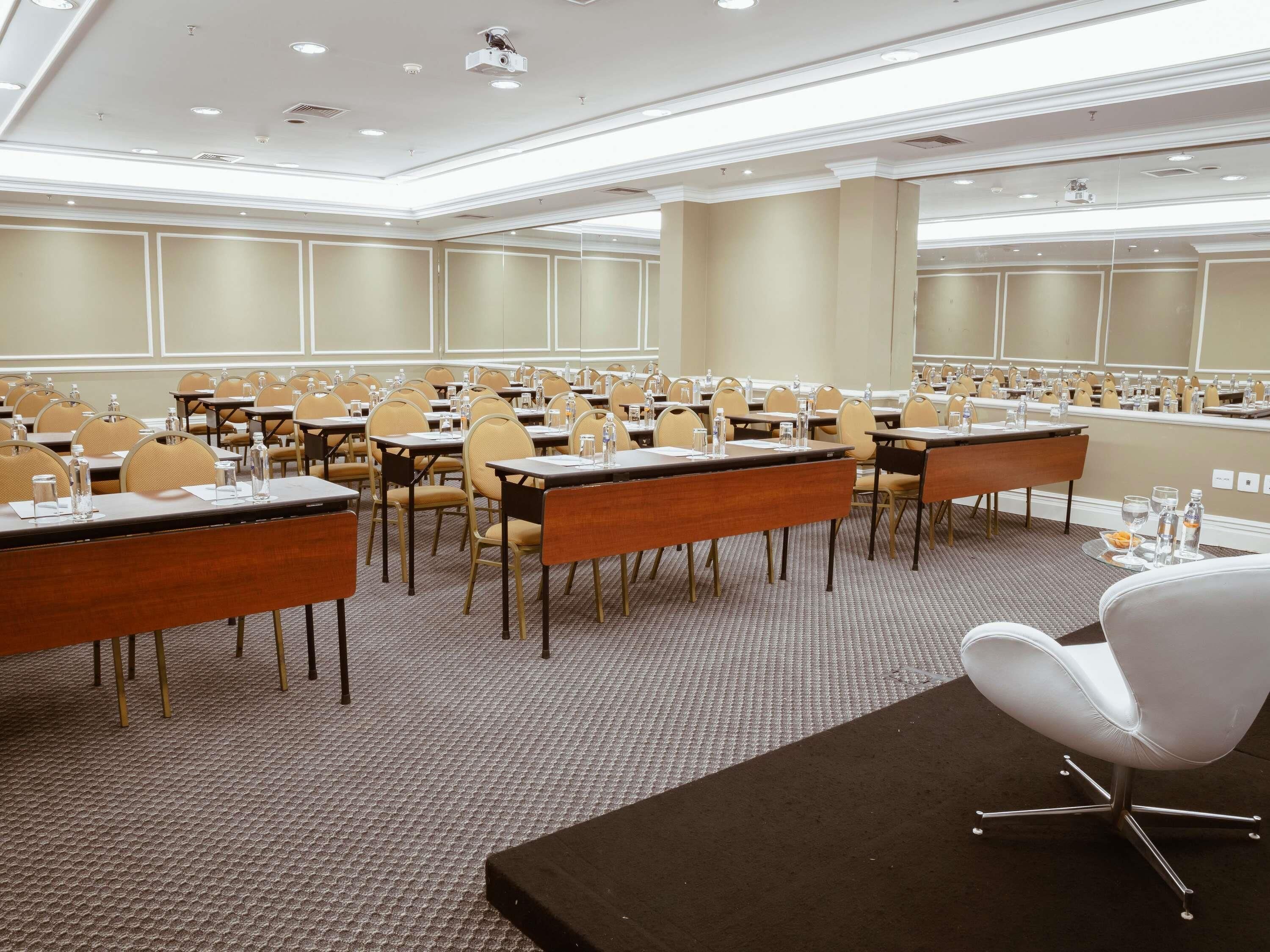 Une salle de conférence équipée de tables, de chaises et d’un projecteur.