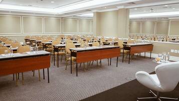 Une salle de conférence équipée de tables, de chaises et d’un projecteur.