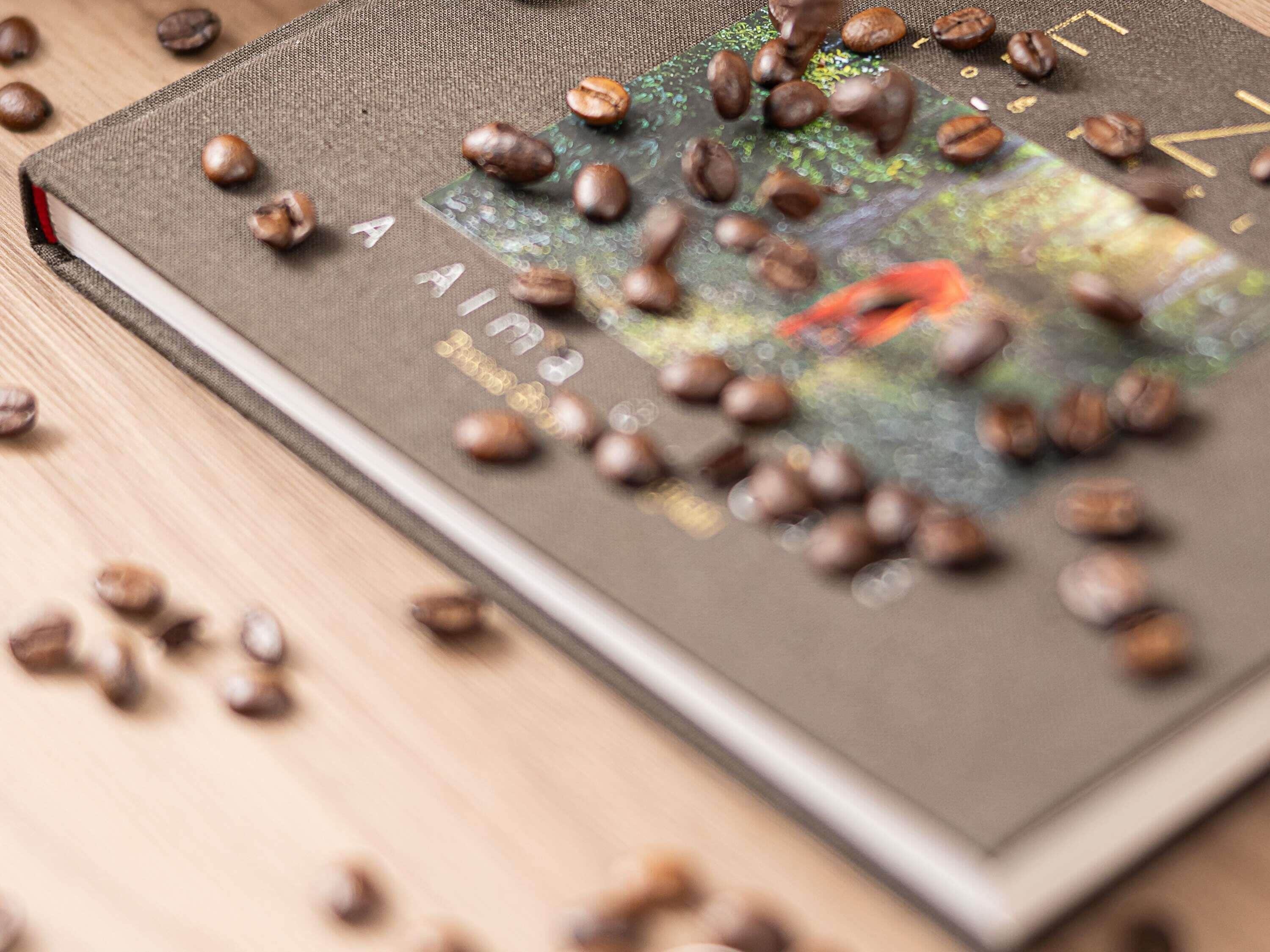 A book with coffee beans scattered on top.