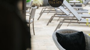 Zona de spa con sillones de descanso y el logotipo de 'THA SPA'.