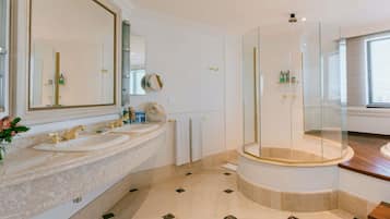 A modern bathroom with two sinks, a large mirror, and a glass-enclosed shower.