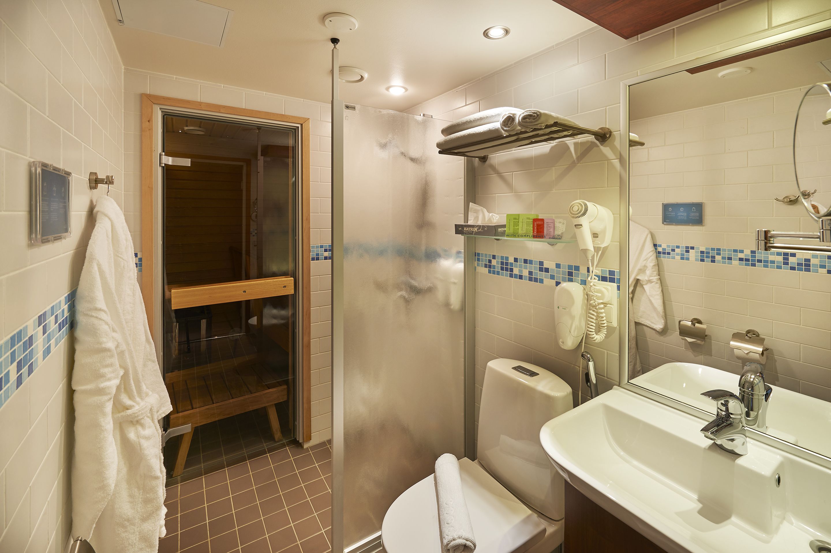 Ein Badezimmer mit Dusche, Waschbecken, Spiegel und Handtuchhalter.