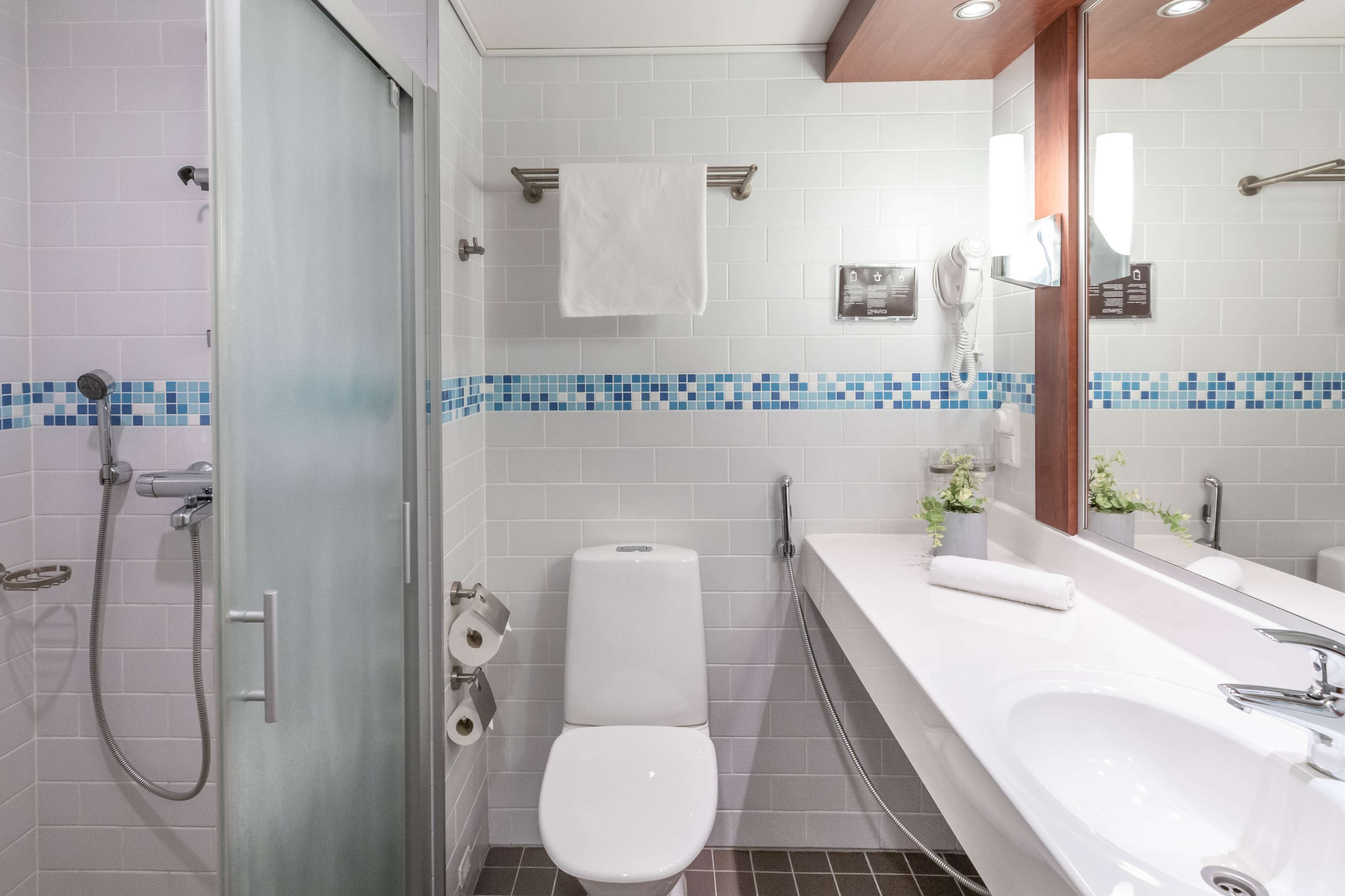 A modern bathroom with a shower, toilet, and sink.