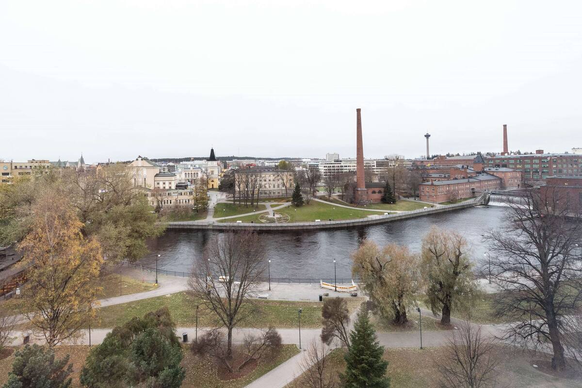 Vista a la orilla del río de un paisaje urbano con edificios históricos, un parque y el río.