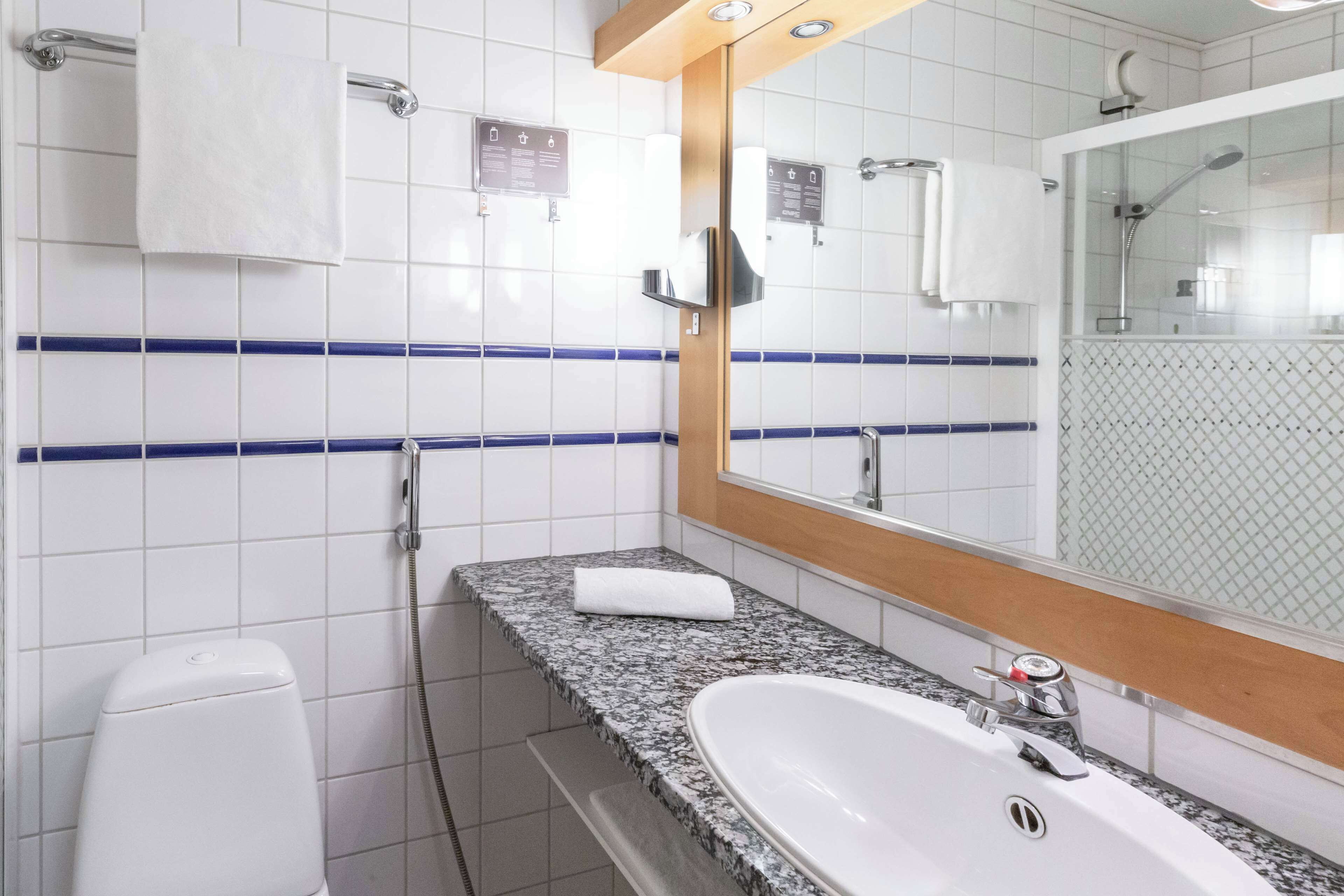A bathroom with a white sink, a mirror, and a shower.